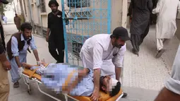 Warga membawa seorang yang terluka akibat serangan bom bunuh diri ke rumah sakit di Quetta, Pakistan, (13/7). Bom bunuh diri tersebut menewaskan 128 orang dan melukai sekitar 150 orang. (AP Photo/Arshad Butt)