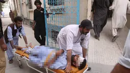 Warga membawa seorang yang terluka akibat serangan bom bunuh diri ke rumah sakit di Quetta, Pakistan, (13/7). Bom bunuh diri tersebut menewaskan 128 orang dan melukai sekitar 150 orang. (AP Photo/Arshad Butt)
