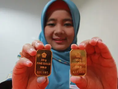 Petugas menunjukan emas batangan di Jakarta, Rabu (13/7). Harga emas batangan atau Logam Mulia milik PT Aneka Tambang Tbk (Antam) hari ini dibuka turun Rp 10.000/gram. (Liputan6.com/Angga Yuniar) 