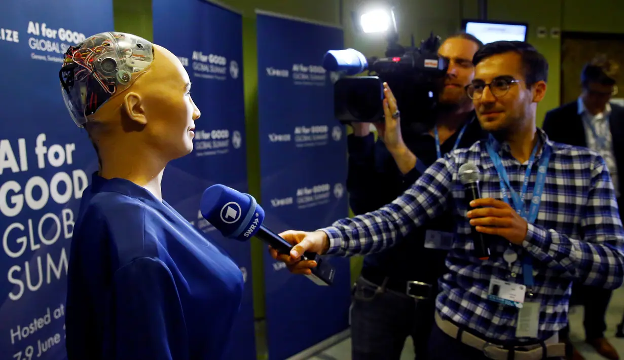 Kru televisi mewawancarai Sophia di sela acara KTT Global "AI for Good" di International Telecommunication Union (ITU) di Jenewa, Swiss (7/6). Robot buatan David Hanson dan tim dari Hanson Robotic ini terbuat dari silikon paten. (Reuters/Denis Balibouse)