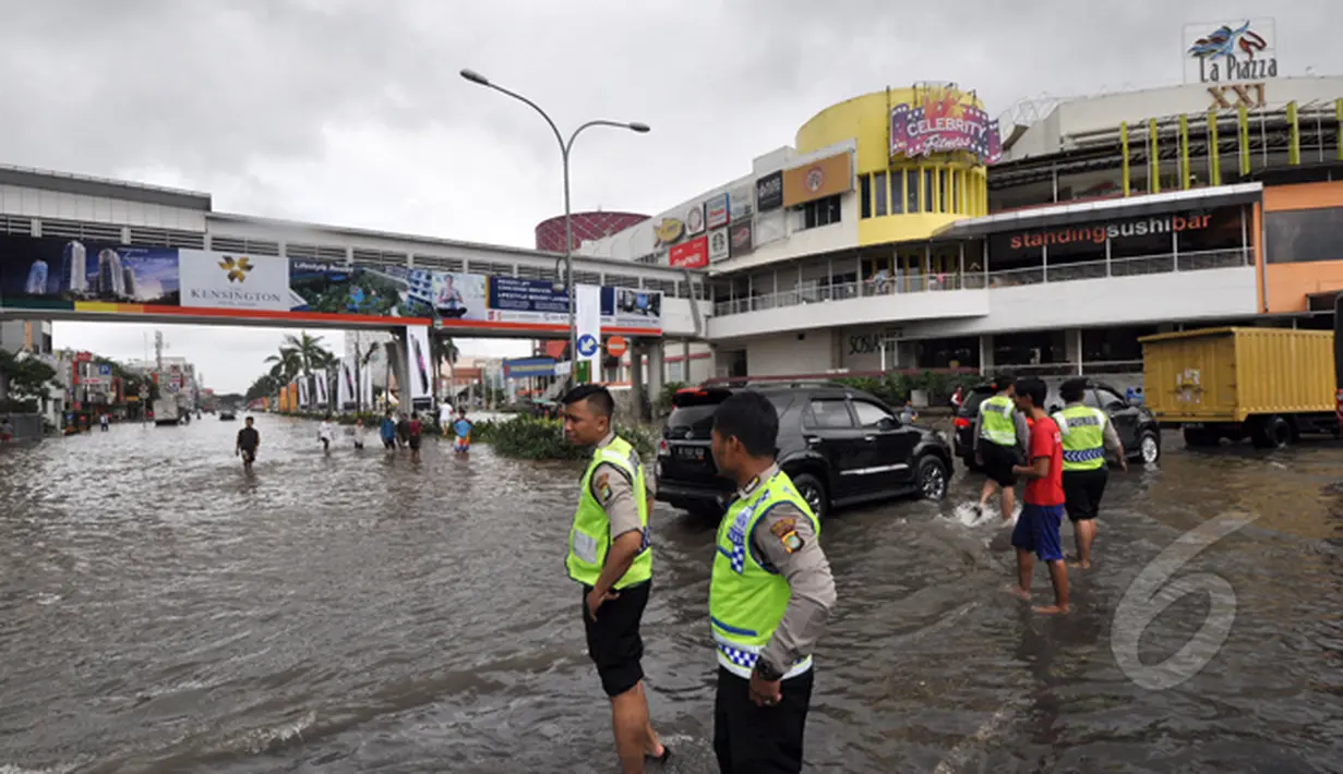  Hujan yang mengguyur Jakarta sejak Minggu (8/2) lalu, mengakibatkan tingginya genangan air di kawasan Kelapa Gading. Tampak sejumlah petugas kepolisian diterjunkan untuk membantu warga, Jakarta, Selasa (10/2/2015). (Liputan6.com/Faizal Fanani)