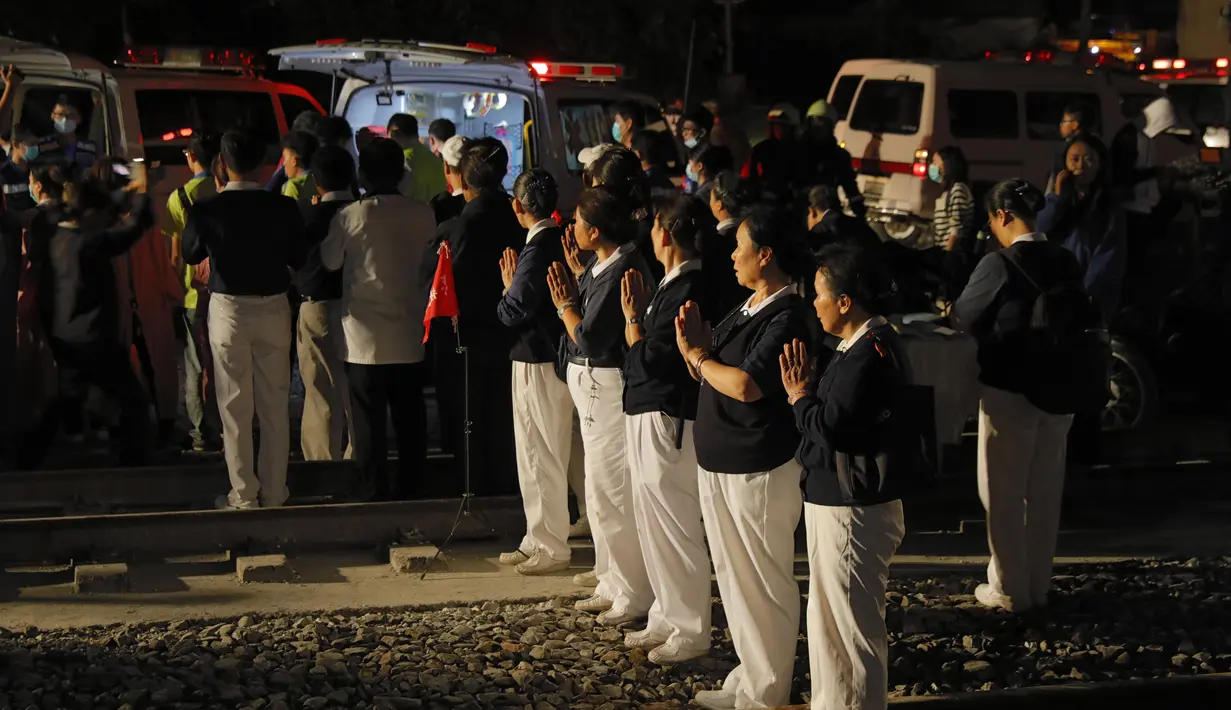 Kelompok Buddhis berdoa di lokasi tergelincirnya kereta Puyuma Express di Yilan, Taiwan, Minggu (21/10). Saksi mengatakan bahwa mereka mendengar suara dentuman keras kemudian melihat percikan api serta asap sebelum kecelakaan. (Daniel M Shih/AFP)