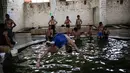 Sejumlah pengunjung saat berada di kolam renang air hangat dari belerang di Hamam Alli, Mosul, Irak, (27/4). Sebelum ISIS mengambil alih Hamam Alil pada 2014, warga Irak selalu mengunjungi spa bersejarah di selatan Mosul ini. (AP Photo/Bram Janssen)