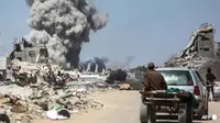 Orang-orang menyaksikan asap mengepul setelah serangan Israel di Jabalia, di Jalur Gaza utara pada 25 Mei 2025. (AFP/Bashar Taleb Basher)