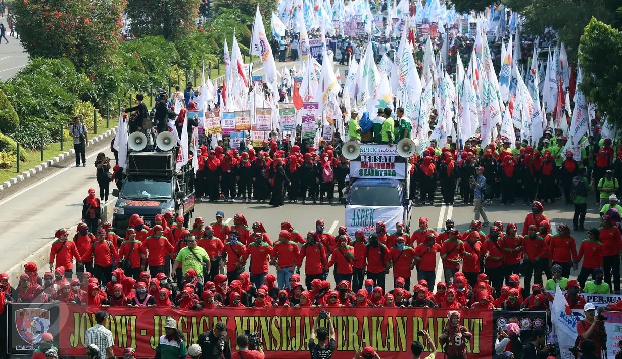 Massa buruh dan pekerja dari berbagai daerah mulai memadati Jalan MH Thamrin, Jakarta, dalam peringatan May Day, Senin (1/5). Mereka mengibarkan bendera organisasi buruh dan membentangkan spanduk di sepanjang perjalanan. (Liputan6.com/Johan Tallo)