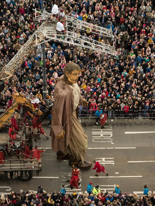 Kerumuman warga melihat boneka raksasa bernama Giant berjalan melintasi dermaga di Liverpool, Inggris, Minggu (7/10). Boneka itu karya dari kelompok teater jalanan Prancis, Royal de Luxe dengan ciri khas aktor berupa Boneka Super Besar. (OLI SCARFF/AFP)