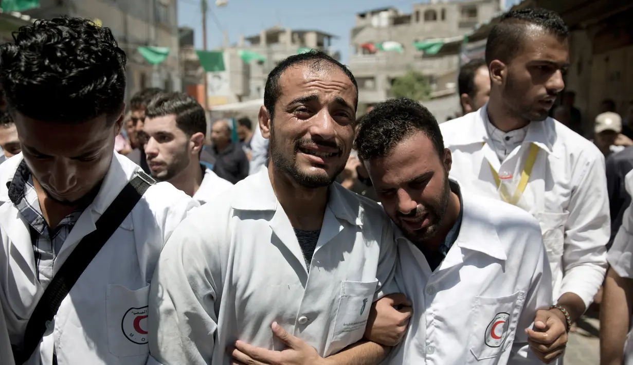 Paramedis Palestina berduka saat pemakaman rekan mereka, Abdullah al-Qutati yang meninggal ditembak tentara Israel, Rafah, Jalur Gaza, Sabtu (11/8). Beberapa waktu lalu Israel juga menembak mati paramedis Gaza, Razan al-Najjar. (AP Photo/Khalil Hamra)