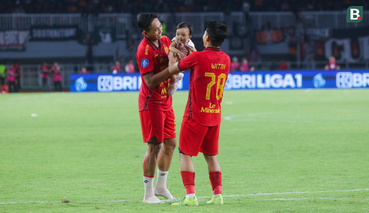 Momen menarik penuh kehangatan tersaji setelah pertandingan Persija Jakarta kontra Persik Kediri pada laga BRI Liga 1 di Stadion Pakansari, Jakarta, Minggu (1/12/2024). Kapten Macan Kemayoran, Rizky Ridho terlihat asyik bermain dengan anak Witan Sulaeman. (Bola.com/M Iqbal Ichsan)