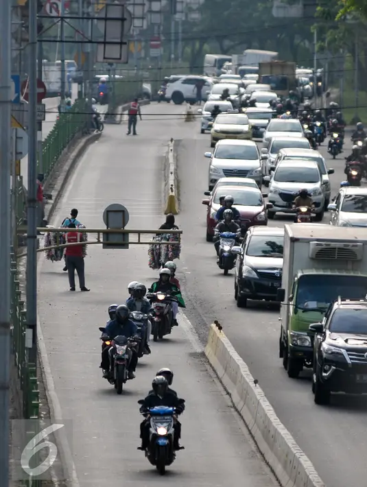 Pengendara motor nekat menerobos jalur Transjakarta meski dijaga petugas di Jalan Sultan Agung, Manggarai, Jakarta, (28/7) Sterilisasi jalur Transjakarta di jalan Sultan Agung, Manggarai belum bisa diterapkan sepenuhnya. (Liputan6.com/Yoppy Renato)