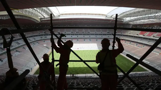 Laborers remove scaffolding at the Al Bayt stadium in Al Khor, Qatar, about 50 kilometers (30 miles) north of Doha, Monday, April 29, 2019.