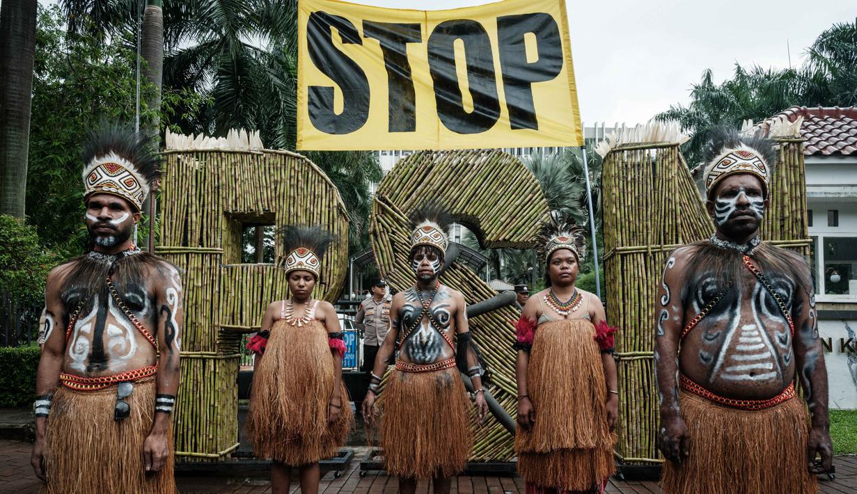 Greenpeace Indonesia mengatakan ambisi Presiden Prabowo bisa membabat jutaan hutan alam dan mengabaikan keberadaan masyarakat adat Papua. Tampak dalam foto, aktivis Greenpeace Indonesia dan bersama beberapa pemuda Papua menggelar aksi teatrikal saat berunjuk rasa di depan Kantor Kementerian Koordinator bidang Perekonomian, Jakarta, Kamis (18/12/2025). (Yasuyoshi Chiba/AFP)