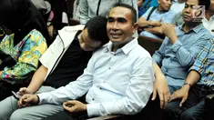 Bupati nonaktif Buton, Samsu Umar Abdul Samiun didampingi keluarganya saat menunggu sidang di Pengadilan Tipikor, Jakarta, Rabu (27/9). Samsu Umar divonis  3 tahun 9 bulan penjara oleh Majelis Hakim. (Liputan6.com/Helmi Afandi)