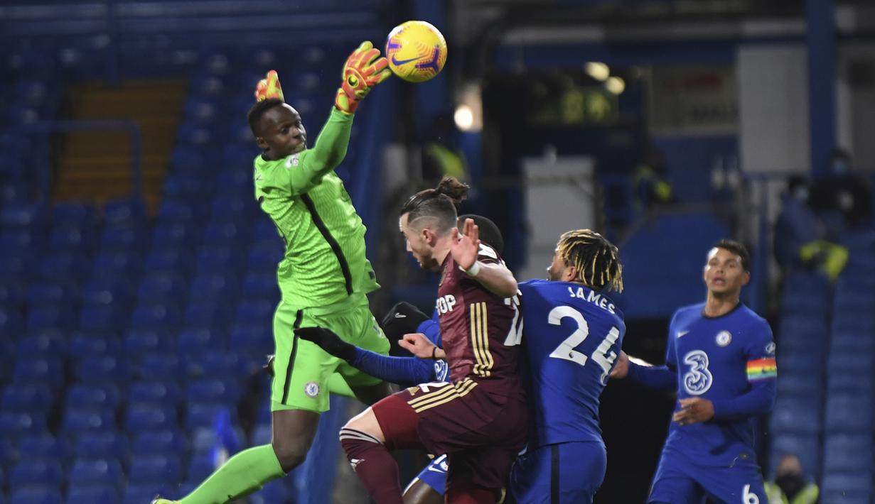 Kiper Chelsea, Edouard Mendy (kiri), melompat untuk menjangkau bola dari ancaman pemain Leeds United dalam laga lanjutan Liga Inggris pekan ke-11 di Stamford Bridge, London, Sabtu (5/12/2020). Chelsea menang 3-1 atas Leeds United. (Pool via AP/Mike Hewitt)