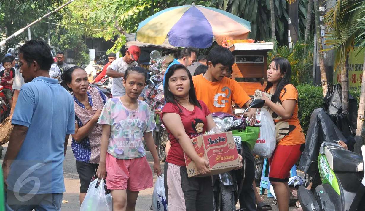 Sejumlah warga berhasil mendapatkan barang yang mereka inginkan, Jakarta, Minggu (21/6/2015). Warga terlihat  antusias membeli pakaian di pasar murah tersebut. (Liputan6.com/Herman Zakharia)