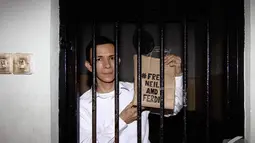 Ferdinant Tjiong memperlihatkan tas kardus bertuliskan #Free Neil and Ferdi saat akan menjalani sidang perdana di Pengadilan Negeri Jakarta Selatan, Selasa (2/12/2014). (Liputan6.com/Faizal Fanani)