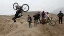 Aksi pemuda Afghanistan saat melakukan lompatan disaksikan para temannya saat mengendarai sepeda Dirt Jump (DJ) di Kabul, Afghanistan (20/11). Sepeda jenis ini awalnya dirancang untuk anak muda perkotaan, sebagai alat transportasi. (Reuters/Omar Sobhani)