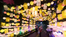 Warga memperhatikan ornamen lampu hias saat llumination of Jakarta: Glow of Peace di kawasan Bundaran Hotel Indonesia, Jakarta, Kamis (28/5/2026). (Kapanlagi.com/Budy Santoso)