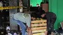 Sejumlah aparat kepolisian berjaga di lokasi dan melakukan penyelidikan untuk memastikan penyebab pasti kebakaran, sementara pihak terkait terus mendata kerugian akibat insiden tersebut. Tampak dalam foto, beberapa pedagang berupaya menyelamatkan sisa dagangannya setelah api yang membakar Pasar Induk Kramat Jati Jakarta berhasil dipadamkan pada Senin (15/12/2025). (merdeka.com/magang/Rendi Saputra)