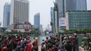 Sejumlah personel keamanan dan petugas penyelamat mengamati proses penurunan aktivis Greenpeace Indonesia yang memanjat Patung Selamat Datang di Bundaran Hotel Indonesia, Jakarta, Selasa (20/10/2026). Aksi tersebut digelar bertepatan dengan dua tahun pelantikan Presiden Prabowo Subianto. Para aktivis mendesak pemerintah mengambil langkah untuk mengatasi krisis iklim yang kian memburuk serta kenaikan biaya hidup. (BAY ISMOYO/AFP)