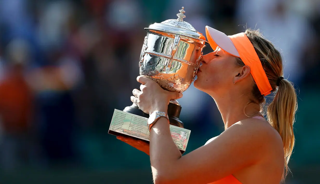 Maria Sharapova mencium trofi Perancis Terbuka usai mengalahkan petenis Rumania, Simona Halep di Stadion Roland Garros, Paris, (7/6/2014). (REUTERS/Vincent Kessler)
