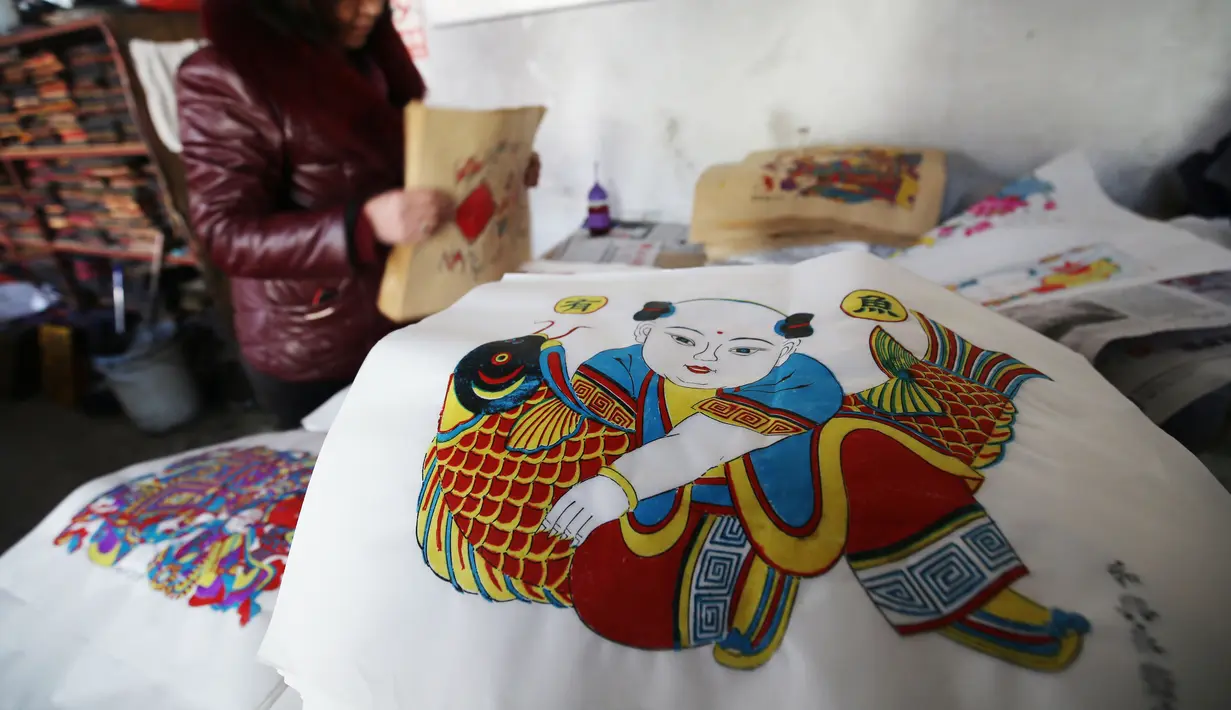 Gambar yang dibuat untuk perayaan tahun baru Imlek di sebuah lokakarya di Weifang di provinsi Shandong, Tiongkok (20/1). Jelang perayaan tahun baru Imlek, para pekerja dan pengrajin pernak-pernik tengah bersiap. (AFP)