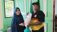 Salah satu petugas Lazismu Garut, Jawa Barat tengah memberikan bantuan kepada warga yang membutuhkan. (Liputan6.com/Jayadi Supriadin)
