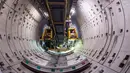 Pekerja dibantu alat berat menyelesaikan pembangunan Line 14 jalur kereta bawah tanah Shanghai, China (11/7). Pada hari kerja, jumlah perjalanan Shanghai Metro mencapai 8 juta per harinya. (AFP Photo/Johannes Eisele)