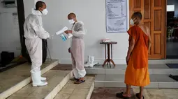 Biksu Buddha mendisinfeksi diri mereka sendiri setelah melakukan kremasi untuk korban virus corona COVID-19 di Wat Chin Wararam Worawihan, Bangkok, Thailand, 30 Juli 2021. Kasus COVID-19 di Thailand kini tengah melonjak. (Lillian SUWANRUMPHA/AFP)