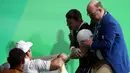 Atlet angkat besi Armenia, Andranik Karapetyan menahan sakit dan menangis usai mengalami cedera horor ketika tampil pada Olimpiade 2016 di Rio de Janeiro, Rabu (10/8). Siku Karapetyan patah saat hendak mengangkat beban 195 kilogram (REUTERS/Yves Herman)
