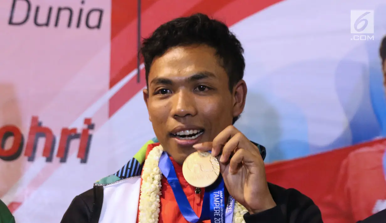 Pelari muda Indonesia, Lalu Muhammad Zohri memperlihatkan medali saat penyambutan di Terminal 3 Bandara Soetta, Tangerang, Selasa (17/7). Lalu M Zohri meraih emas lari 100m putra di Kejuaraan Dunia Atletik U-20. (Liputan6.com/Helmi Fithriansyah)