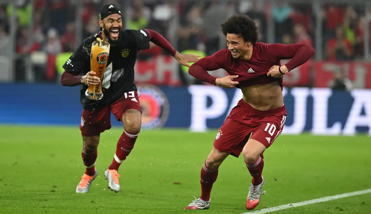 <p>Gelandang Bayern Munchen Leroy Sane (kanan) dikejar oleh rekannya Eric Maxim Choupo-Moting dengan bir saat berselebrasi pada akhir pertandingan pekan ke-31 Bundesliga musim 2021/2022 saat menjamu Borussia Dortmund di Allianz Arena, Minggu (24/4/2022) dini hari WIB. Bayern Munchen kembali menjadi juara Bundesliga usai menghajar rivalnya Borussia Dortmund 3-1. (KERSTIN JOENSSON / AFP)</p>