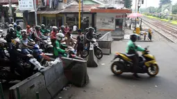 Pengendara motor melintas di perlintasan kereta api di kawasan Roxy, Jakarta, Rabu (21/3). Petugas Sudinhub Jakpus telah menutup akses perlintasan KA di depan Roxy 20 September 2017, namun mendapat protes keras dari warga.  (Liputan6.com/Arya Manggala)