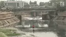 Pekerja membersihkan sampah yang mengotori aliran Kanal Banjir Timur (KBT) di Jakarta, Sabtu (15/9). Banyaknya limbah rumah tangga dan limbah industri menyebabkan kanal pengendali banjir tersebut selalu tercemari sampah. (Liputan6.com/Immanuel Antonius)