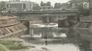 Pekerja membersihkan sampah yang mengotori aliran Kanal Banjir Timur (KBT) di Jakarta, Sabtu (15/9). Banyaknya limbah rumah tangga dan limbah industri menyebabkan kanal pengendali banjir tersebut selalu tercemari sampah. (Liputan6.com/Immanuel Antonius)