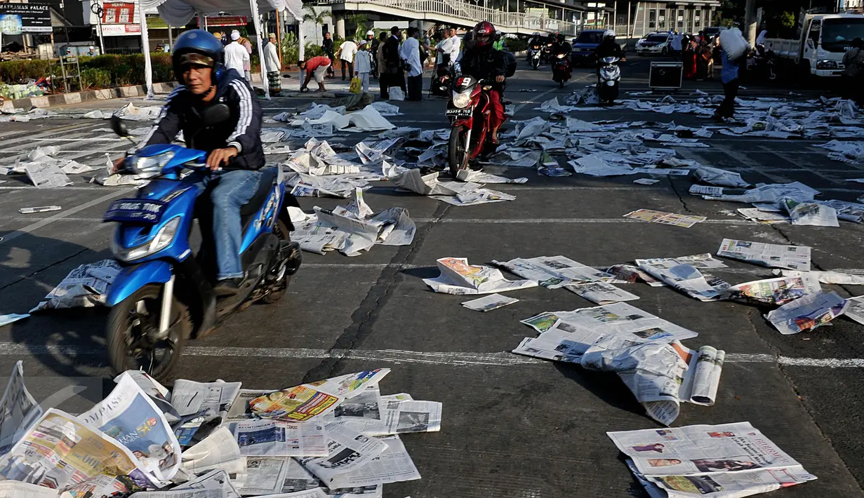 Lembaran koran bekas ditinggalkan begitu saja pasca pelaksanaan salat Hari Raya Idul Fitri 1436 H di ruas jalan Jatinegara Barat, Jakarta, Jumat (17/7/2015). Sampah koran berceceran hingga mengganggu pengguna jalan lainnya. (Liputan6.com/Johan Tallo)