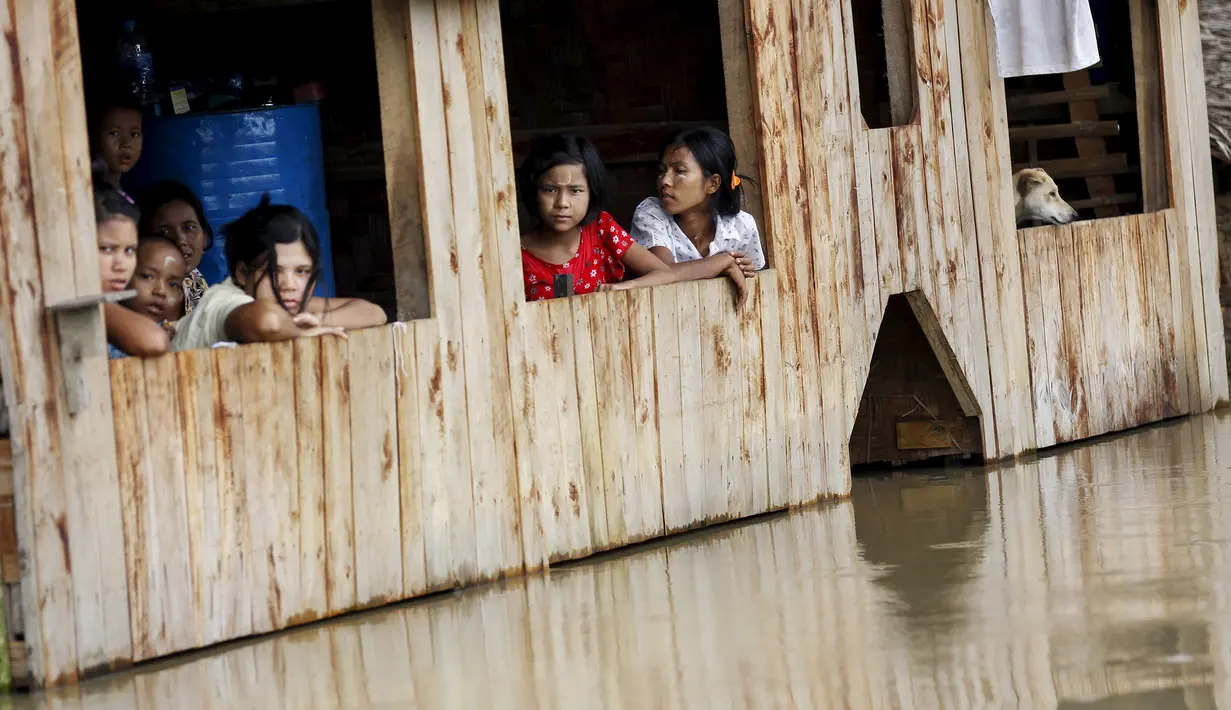 Warga Myanmar duduk dirumah sambil menunggu air surut di Zalun Township, Irrawaddy Delta, Myanmar (6/8/2015). Presiden Myanmar mendesak warganya untuk segera meninggalkan wilayah tempat tinggalnya yang digenangi banjir parah. (REUTERS/Soe Zeya Tun)