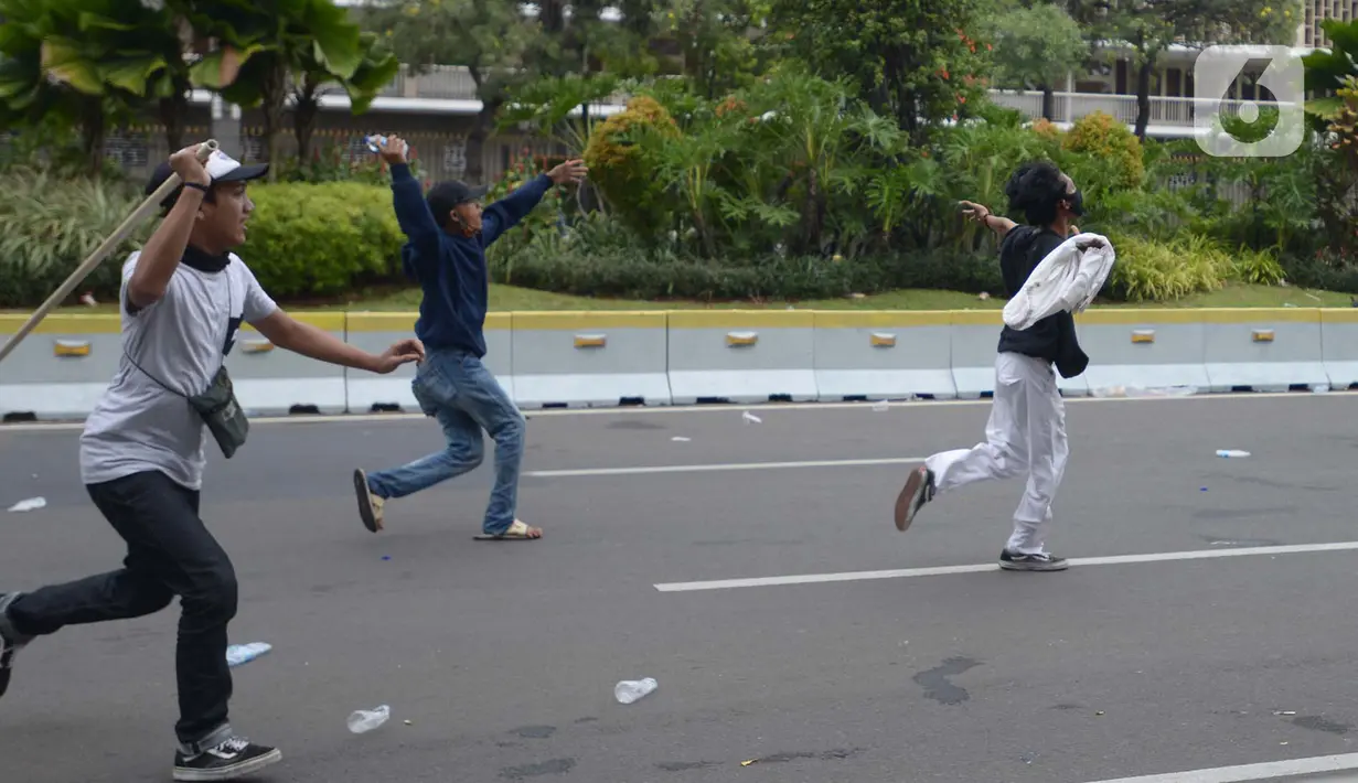 Pengunjuk rasa tolak UU Cipta Kerja bentrok dengan polisi di Kawasan Thamrin, Jakarta Pusat, Selasa (13/10/2020). Gas air mata ditembakkan ke arah pendemo yang melakukan perlawanan dengan melempar batu dan pecahan kaca. (merdeka.com/Imam Buhori)