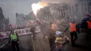 Seorang pria menggendong seorang anak dan melambaikan obor saat ribuan orang berkumpul di pusat kota untuk pawai Hari Kemerdekaan tahunan di Warsawa, Polandia, 11 November 2022. Pawai ini diselenggarakan oleh kelompok-kelompok nasionalis yang telah ditandai dengan kekerasan dalam beberapa tahun terakhir. (AP Photo/Michal Dyjuk)