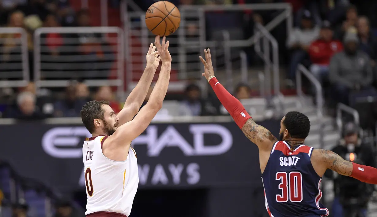 Aksi pemain Cleveland Cavaliers, Kevin Love (0) mencetak poin saat diadang pemain Wizards, Mike Scott (30) pada laga NBA basketball game di Capital One Arena, Washington, (17/12/2017). Cleveland menang 106-99. (AP/Nick Wass)