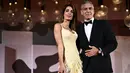 Aktor George Clooney dan istrinya Amal Clooney menghadiri pemutaran perdana film 'Wolfs' pada Festival Film Venice ke-81 di Venesia, Italia, pada Minggu (1/9/2024).  (Photo by Marco BERTORELLO / AFP)