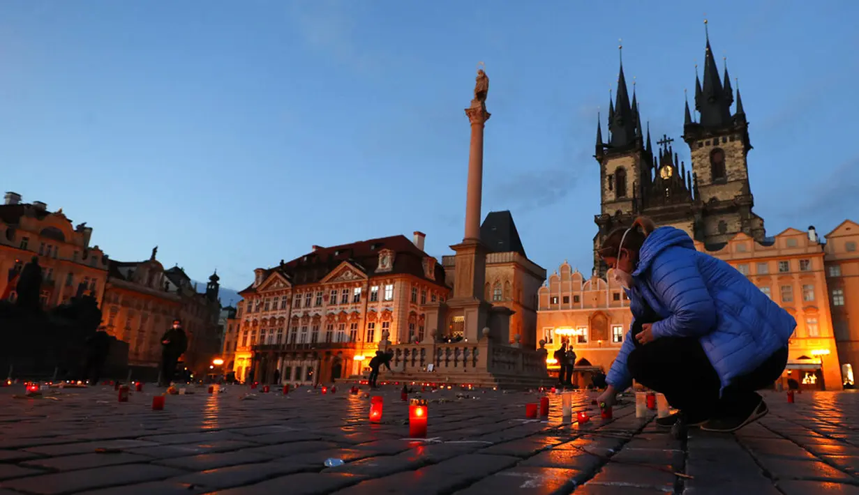 Seorang wanita menyalakan lilin untuk memberi penghormatan kepada para korban pandemi COVID-19 di Alun-Alun Kota Tua, Praha, Republik Ceko, Senin (29/3/2021). Pandemi COVID-19 menimbulkan penderitaan yang luar biasa di seluruh Eropa tengah, termasuk Republik Ceko. (AP Photo/Petr David Josek)