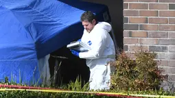 Seorang tim investigasi mengecek barang bukti di lokasi penembakan massal di Borderline Bar & Grill di Thousand di Thousand Oaks, California (8/11). Pelaku penembakan tewas dengan melakukan tembakan bunuh diri. (AFP Photo/Robyn Beck)
