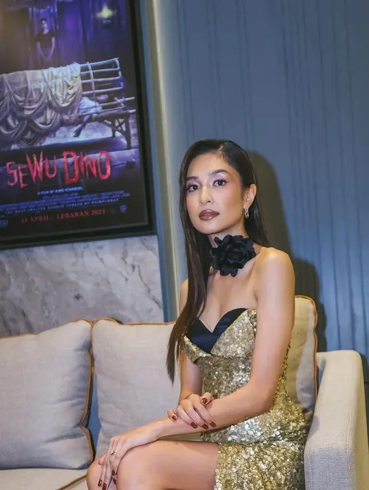 Kali ini ia mengambil tema glamor memakai strapless dress warna gold. Gaun sequin bling bling tersebut merupakan rancangan desainer Yogie Pratama. [Foto: @miktambayong]