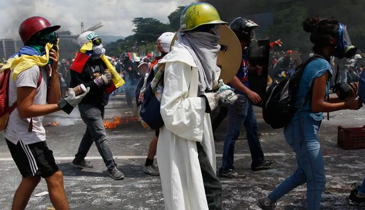 Demonstran anti- Nicolas Maduro memegang botol tinja untuk dilemparkan ke polisi anti huru-hara di Caracas, Venezuela, 10 Mei 2017. Mereka kini menggunakan bom 'poopootov' untuk menyerang petugas yang menghalangi jalannya demo. (AP Photo/Ariana Cubillos)