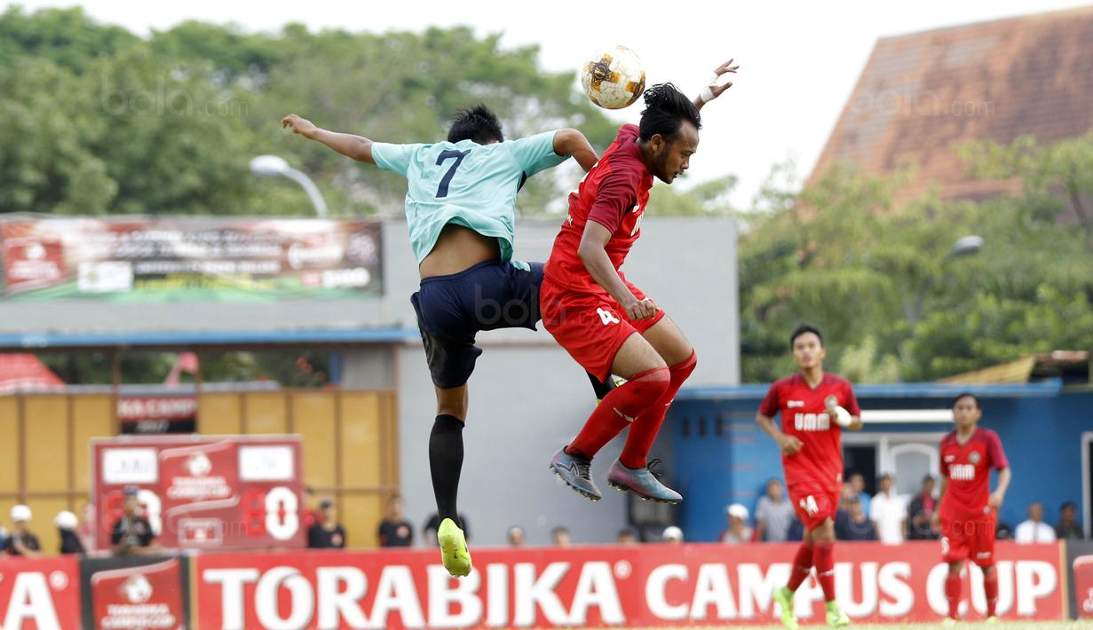 Pemain Universitas Muhammadiyah Malang (UMM), Diki, duel udara dengan pemain Universitas Negeri Malang (UM), Gana, pada laga final Torabika Campus Cup 2017 di Stadion UM, Malang, Kamis, (02/11/2017). UMM menang 2-0 atas UM. (Bola.com/M Iqbal Ichsan)