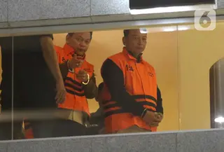 Tiga di antaranya merupakan pejabat di lingkungan Pengadilan Negeri (PN) Depok. Tampak dalam foto, Ketua Pengadilan Negeri Depok, I Wayan Eka Mariarta (kanan) bersama Wakil Ketua Pengadilan Negeri Depok, Bambang Setyawan, sesaat sebelum dibawa menuju mobil tahanan di Gedung Merah Putih Komisi Pemberantasan Korupsi (KPK), Jakarta, Sabtu (7/2/2026). (Liputan6.com/Helmi Fithriansyah)