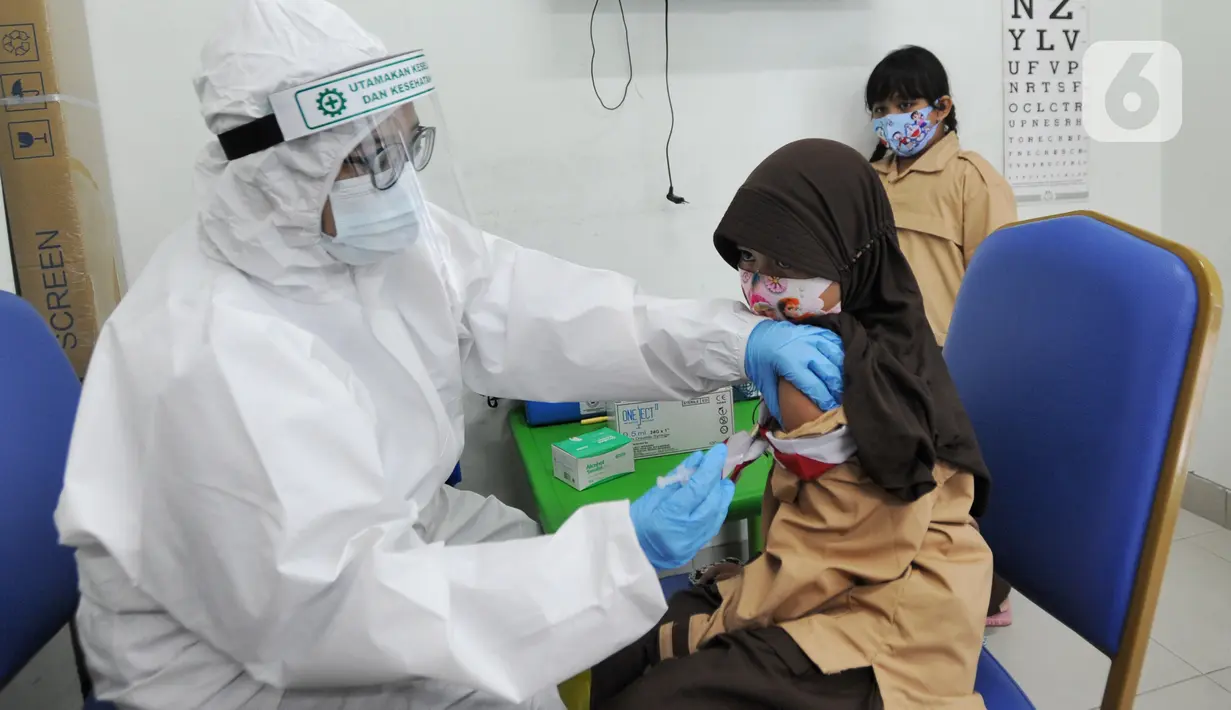 Dokter memberikan imunisasi campak kepada murid baru sekolah dasar negeri di Puskesmas Pondok Labu, Jakarta Selatan, Rabu (12/8/2020). Selain dalam rangka Bulan Imunisasi Anak Sekolah, kegiatan ini juga bagian dari pemeriksaan kesehatan murid baru sekolah dasar negeri. (merdeka.com/Arie Basuki)