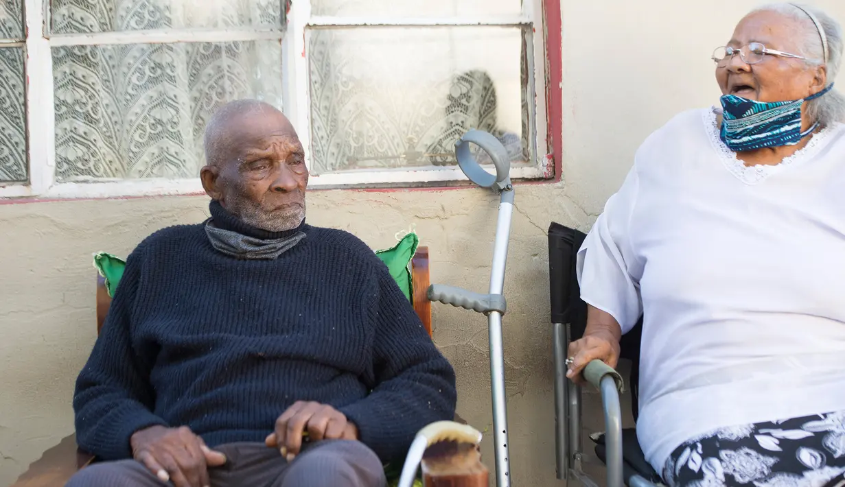 Fredie Blom (kiri) ditemani istrinya, Jeanette (86) ketika merayakan ulang tahun ke 116 di rumahnya di Delft, dekat Cape Town, 8 Mei 2020. Menurut 'Oupa' (kakek) Fredie dan kartu identitasnya, ia lahir pada tahun 1904 yang menjadikannya salah satu pria tertua di dunia. (RODGER BOSCH/AFP)