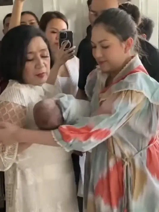 Setelah prosesi tersebut, Jessica pun memberikan bayi cantiknya kepada mamah mertua untuk digendong. Tampak, jessica tampil dengan gaya rambut bunny. [@ramaphoto07]