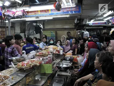 Puluhan pembeli antre untuk mendapatkan kue kering untuk Lebaran di Pasar Jatinegara, Jakarta, Selasa (5/6). Meskipun Idul Fitri masih dua pekan lagi, namun toko kue kering di Pasar Jatinegara mulai diserbu pembeli. (Merdeka.com/ Iqbal S. Nugroho)